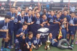 Los jugadores del Motagua U-14 celebran con la copa de campeón.
