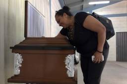 Un pariente de José Zúniga llora sobre su ataúd en su sepelio.