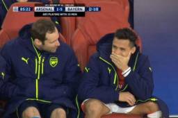 Alexis Sánchez junto a Petr Cech en el banquillo del Arsenal.