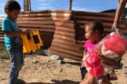 Enrique y Génesis muy felices con los juguetes que el futbolista de Motagua les regaló.
