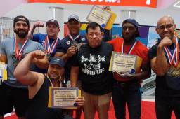 Juan Zapata (camisa roja) posando con su reconocimiento y medalla de oro.