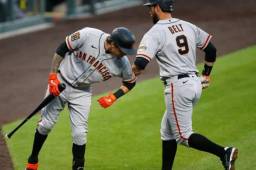 Brandon Belt es felicitado por su compañero luego de conectar un jonrón de tres carreras en la cuarta entrada del duelo ante los Rockies de Colorado.