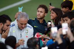 Neymar firma autógrafos y regala fotos a los aficionados en el campo de entrenamiento de la Selección de Brasil que se prepara para el Mundial. Foto AFP