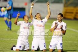 Los jugadores del Olimpia, Michael Chirinos (izquierda) y Marcelo Canales (derecha) celebran con Roger Rojas los goles anotados al Vida. Foto Juan Salgado