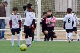 El árbitro David Téllez ayudando a un niño arquero a colocar su barrera nates de un lanzamiento de tiro libre.
