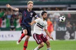 Rakitic pelea el balón con Rodolfo Pizarro.