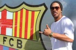 Ronaldinho posando junto al escudo del Barcelona.