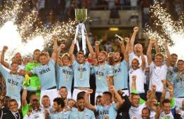 Lazio's players celebrate with the trophy after winning the Italian SuperCup TIM football match Juventus vs lazio on August 13, 2017 at the Olympic stadium in Rome. / AFP PHOTO / Alberto PIZZOLI