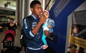Anthony Lozano carga a su hija al llegar al aeropuerto de San Pedro Sula.