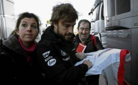 Fernando Alonso firmando autógrafo minutos antes de iniciar su práctica. (Fotos: EFE)