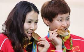 Las chinas Jinjie Gong y Tianshi Zhong celebran la medalla de oro en la prueba de velocidad por equipos de ciclismo de pista femenino. Foto EFE.