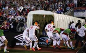 Los futbolistas se tuvieron que retirar tapándose el rostro luego que les lanzaran objetos desde las gradas.