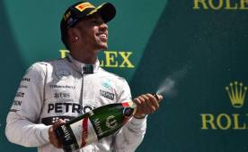 El piloto británico Lewis Hamilton festeja con champagne su nuevo triunfo. (AFP)