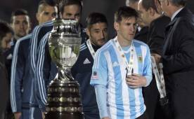 Lionel Messi pasando al lado de la copa que quiso levantar con Argentina.