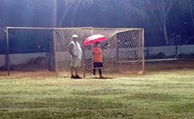 Don Leonel estuvo a un lado de su nieto mientras caía una fuerte lluvia, cada vez que atacaba el rival el pequeño Fernando le entregaba el paraguas y salía a tapar todo. Foto Cortesía Edward Fernández