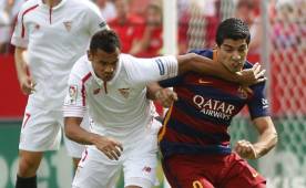 El defensa francés del Sevilla Timothée Kolodziejczak (i) disputa un balón con el delantero uruguayo del FC Barcelona, Luis Suárez.