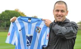 Joel Cole presentando su nueva camiseta en el fútbol inglés.