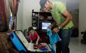 Orlin Vallecillo junto a su hijo Caleb cuando arreglaba maletas para el viaje.
