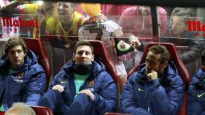 Messi arrancó en el banco y detrás de él muchos aficionados gozaban con el muñeco que llevaron. (EFE)