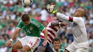 Tim Howard despeja un balón ante el acoso del atacante Chicharito Hernández.
