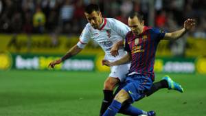 Andrés Iniesta recibe la marca del jugador del Sevilla.
