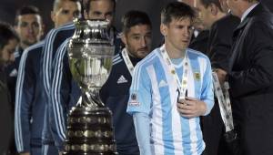 Lionel Messi pasando al lado de la copa que quiso levantar con Argentina.