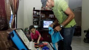 Orlin Vallecillo junto a su hijo Caleb cuando arreglaba maletas para el viaje.