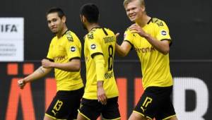 Dortmund's Portuguese defender Raphael Guerreiro (L) celebrates with Dortmund's German midfielder Mahmoud Dahoud (C) and Dortmund's Norwegian forward Erling Braut Haaland after scoring his side's second goal during the German first division Bundesliga football match BVB Borussia Dortmund v Schalke 04 on May 16, 2020 in Dortmund, western Germany as the season resumed following a two-month absence due to the novel coronavirus COVID-19 pandemic. (Photo by Martin Meissner / POOL / AFP) / DFL REGULATIONS PROHIBIT ANY USE OF PHOTOGRAPHS AS IMAGE SEQUENCES AND/OR QUASI-VIDEO