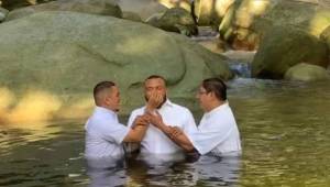 Emil Martínez mientras estaba siendo bautizado por los pastores de su congregación.
