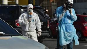 Los medios de comunicación autorizados en Honduras, andan bien protegidos haciendo las coberturas de la pandemia en los hospitales. Fotos AFP