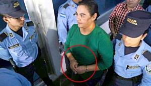Momentos cuando la esposa de Pepe Lobo, Rosa Elena Bonilla, ingresaba a los tribunales, esposada y custodiada por una policía. Foto cortesía