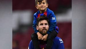 Messi carga a su hijo mayor Thiago en la cancha del Camp Nou.