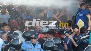 Momentos en que una tanqueta con agua intentaba dispersar a cientos de aficionados que buscaban ingresar cuando el estadio estaba repleto.