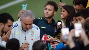Neymar firma autógrafos y regala fotos a los aficionados en el campo de entrenamiento de la Selección de Brasil que se prepara para el Mundial. Foto AFP