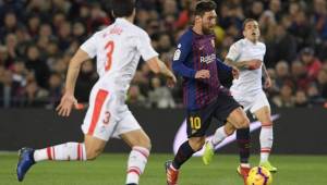 Lionel Messi contralando el esférico ante la mirada de dos marcas.