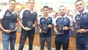 Los jugadores del Motagua, Roberto Moreira, Mathías Galvaliz, Omar Elvir y Denil Maldonado, posando con el libro de los 90 años del ciclón. Fotos cortesía Motagua