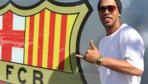 Ronaldinho posando junto al escudo del Barcelona.
