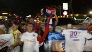 Los aficionados de Olimpia sacaron las banderas y se lanzaron a la calle para armar la fiesta blanca. Foto/Delmer Martínez.