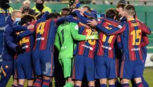 Barcelona players celebrate their victory after the penalty shoot-out in Spanish Super Cup semi final football match between Real Sociedad and FC Barcelona at the Nuevo Arcangel stadium in Cordoba on January 13, 2021. (Photo by CRISTINA QUICLER / AFP)