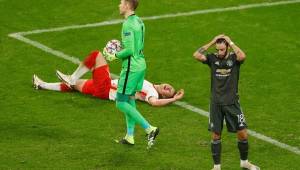 Manchester United's Portuguese midfielder Bruno Fernandes (R) reacts next to Leipzig's Hungarian goalkeeper Peter Gulacsi holding the ball as Leipzig's Hungarian defender Willi Orban lays on the ground during the UEFA Champions League Group H football match RB Leipzig v Manchester United in Leipzig, eastern Germany, on December 8, 2020. (Photo by Odd ANDERSEN / various sources / AFP)