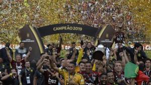 Players of Brazil's Flamengo celebrate on the podium with the trophy after winning the Copa Libertadores final football match by defeating Argentina's River Plate, at the Monumental stadium in Lima, on November 23, 2019. (Photo by Ernesto BENAVIDES / AFP)