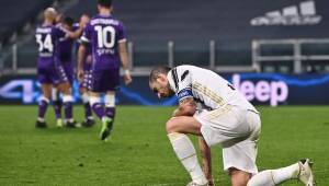 Juventus' Italian defender Leonardo Bonucci (R) reacts as Fiorentina's players celebrate (Rear L) after Juventus scored an own goal during the Italian Serie A football match Juventus vs Fiorentina on December 22, 2020 at the Juventus stadium in Turin. (Photo by Marco BERTORELLO / AFP)