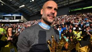 Manchester City's Spanish manager Pep Guardiola shows the Premier League trophy to supporters after their 4-1 victory in the English Premier League football match between Brighton and Hove Albion and Manchester City at the American Express Community Stadium in Brighton, southern England on May 12, 2019. - Manchester City held off a titanic challenge from Liverpool to become the first side in a decade to retain the Premier League on Sunday by coming from behind to beat Brighton 4-1 on Sunday. (Photo by Glyn KIRK / AFP) / RESTRICTED TO EDITORIAL USE. No use with unauthorized audio, video, data, fixture lists, club/league logos or 'live' services. Online in-match use limited to 120 images. An additional 40 images may be used in extra time. No video emulation. Social media in-match use limited to 120 images. An additional 40 images may be used in extra time. No use in betting publications, games or single club/league/player publications. /