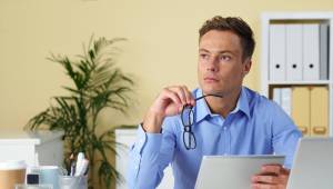 Portrait of contemplating businessman with digital tablet