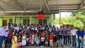 Plantilla y directiva del Victoria posa para el lente junto a los niños de la Escuela La Libertad de Sambo Creek.