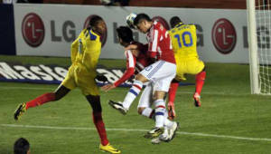 Los jugadores Frickson Erazo y Walter Ayovi pelean el balón contra Darío Verón de Paraguay.