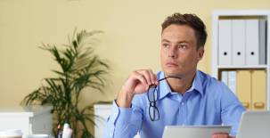 Portrait of contemplating businessman with digital tablet