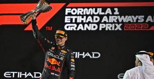 El piloto holandés de Red Bull, Max Verstappen, levanta el trofeo de ganador en el podio después del Abu Dhabi.