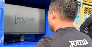 El árbitro Armando Castro revisa el FVS-VAR durante un encuentro del torneo Clausura de la liga hondureña.