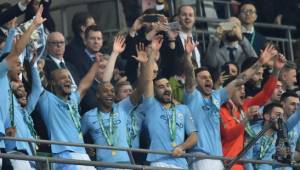 Manchester City's Belgian defender Vincent Kompany (3L) lifts the trophy as Manchester City players celebrate their victory in the English League Cup final football match between Manchester City and Chelsea at Wembley stadium in north London on February 24, 2019. (Photo by Glyn KIRK / AFP) / RESTRICTED TO EDITORIAL USE. No use with unauthorized audio, video, data, fixture lists, club/league logos or 'live' services. Online in-match use limited to 75 images, no video emulation. No use in betting, games or single club/league/player publications. /